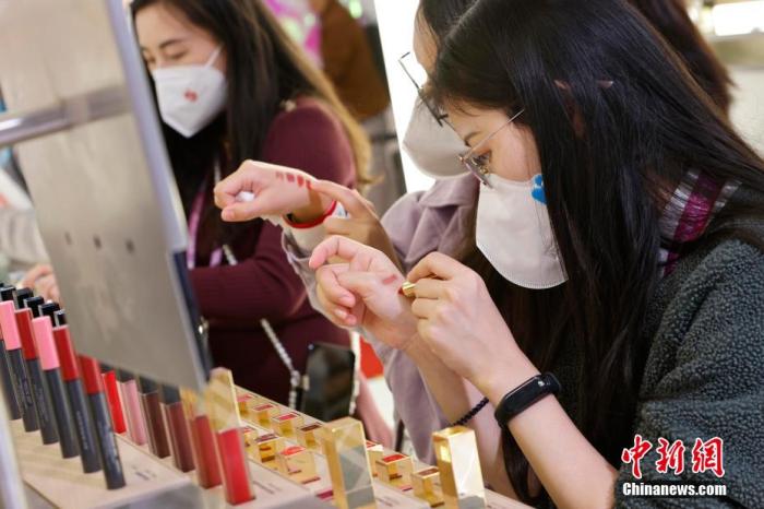 圖為女生正在體驗(yàn)口紅產(chǎn)品。 殷立勤 攝