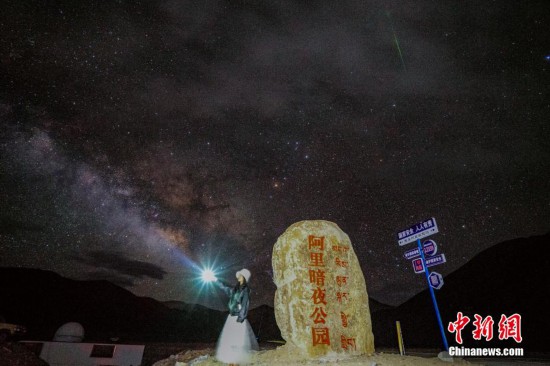 圖為6月20日晚，游客“打卡”西藏阿里暗夜公園，天上是銀河與流星（右上角）。曹枝清 攝