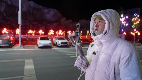 在吉林市阿什哈達(dá)霧凇觀景帶，霧凇播報(bào)員正在直播。新華社記者 李典 攝