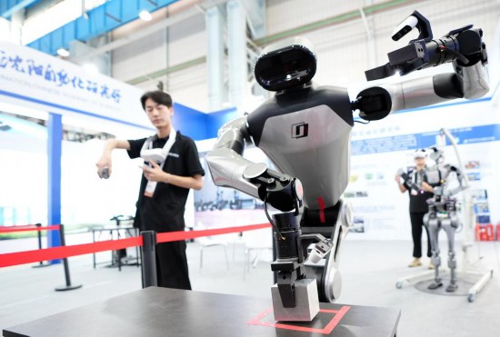 9月5日，在沈陽(yáng)的2025全球工業(yè)互聯(lián)網(wǎng)大會(huì)的展覽區(qū)現(xiàn)場(chǎng)，中國(guó)科學(xué)院沈陽(yáng)自動(dòng)化研究所的機(jī)器人工程師在調(diào)試具身智能操作系統(tǒng)。新華社記者 李鋼 攝