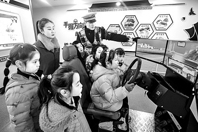 山東省榮成市公安局道路交通安全宣傳教育基地，交警帶領(lǐng)小學(xué)生現(xiàn)場(chǎng)體驗(yàn)?zāi)M駕駛。新華社發(fā)