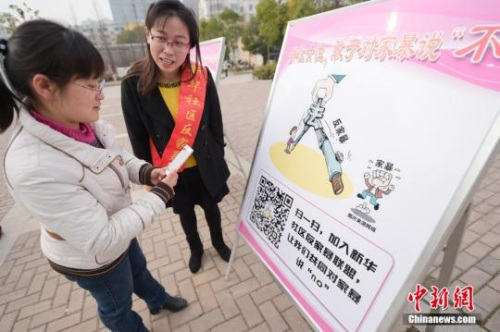 資料圖：今年3月8日，安徽合肥新華社區(qū)志愿者夏一瓊(右)向市民普及反家暴相關(guān)法律知識(shí)。鐘欣 攝