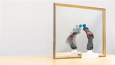  圖為機器人觀察自己在鏡子中的倒影，學習自身的形態(tài)和運動學，實現(xiàn)自主模擬。圖片來源：美國哥倫比亞大學